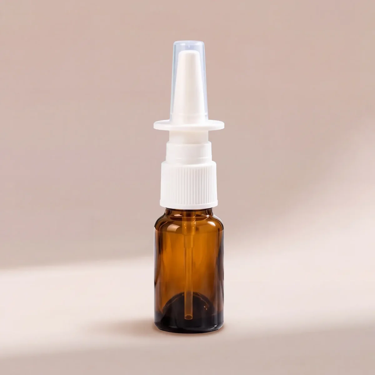 Empty nasal spray bottle — amber glass with white nasal pump and clear cap